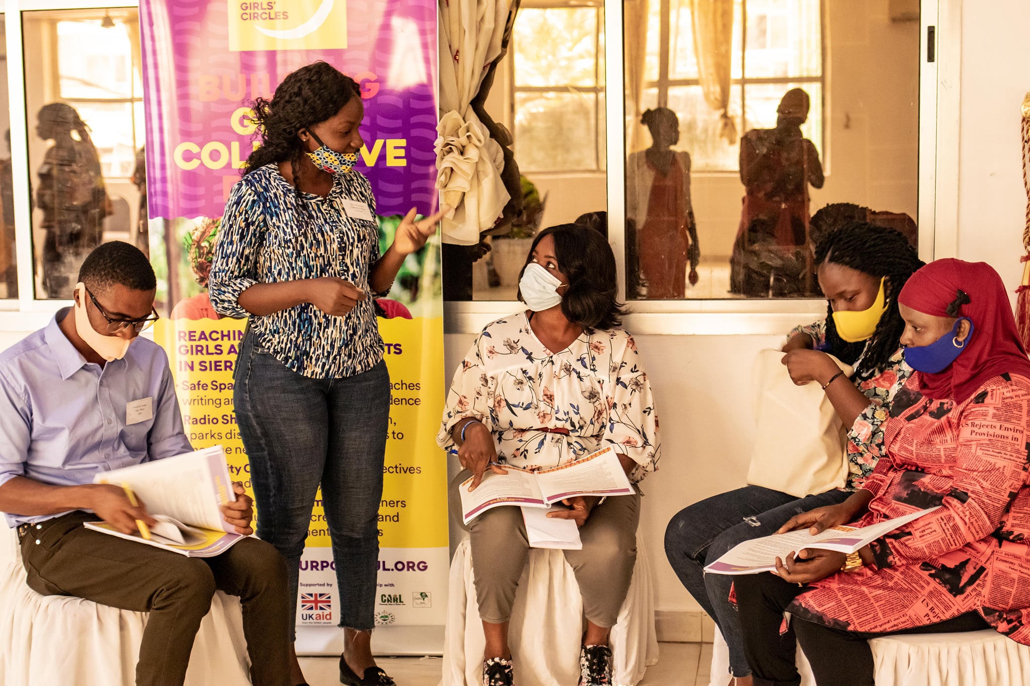 Group of four individuals wearing protective masks being taught in a Purposeful development session