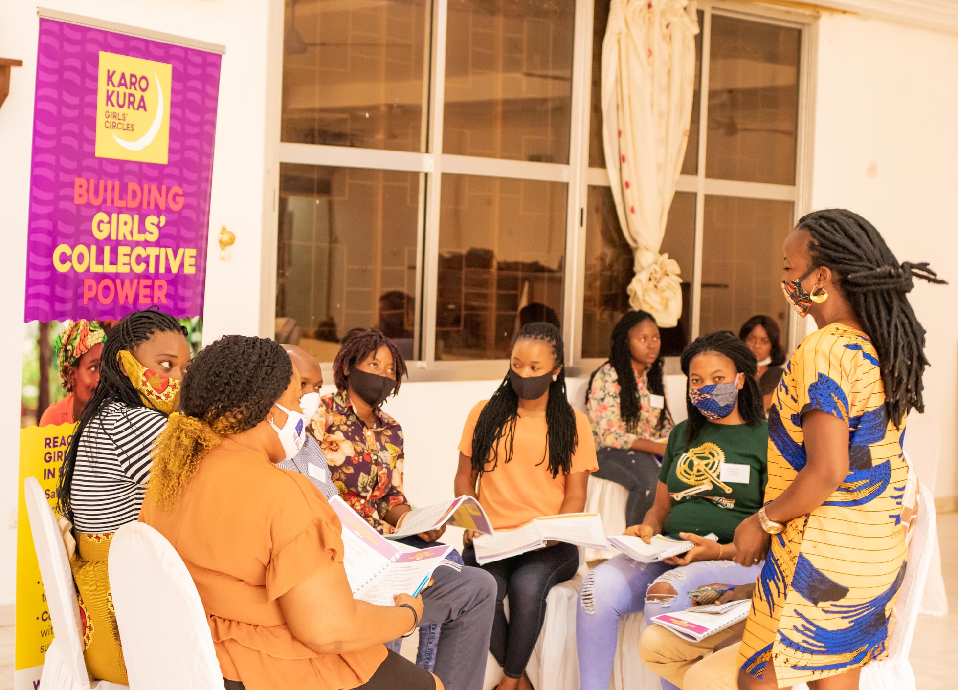 Circle of young women in protective masks being led in development sessions by Purposeful