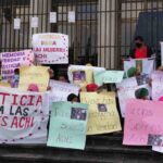 Indigenous women outside of Guatemala's highest court holding handmade signs