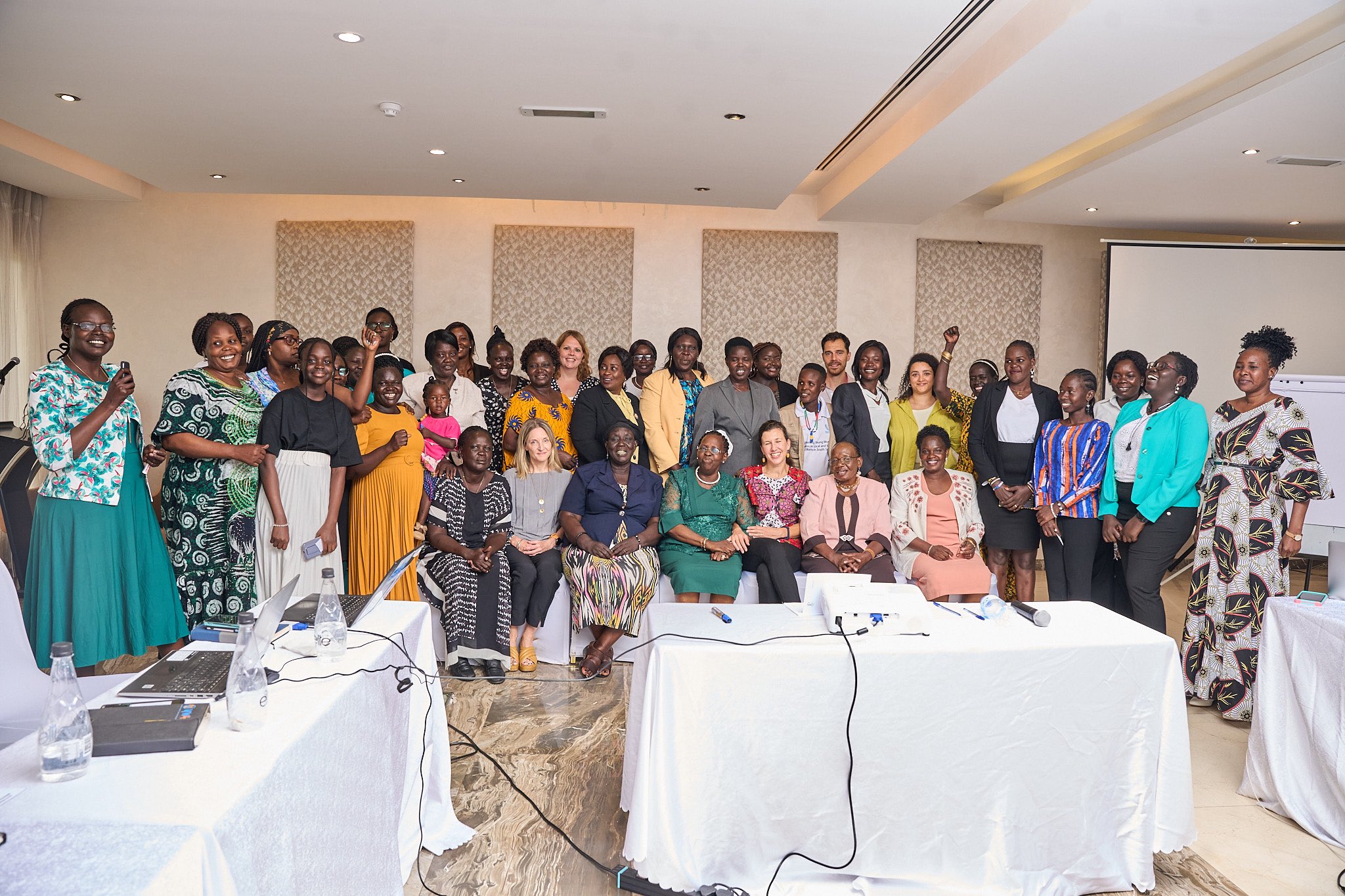 large group of people posing for photo behind set of tables