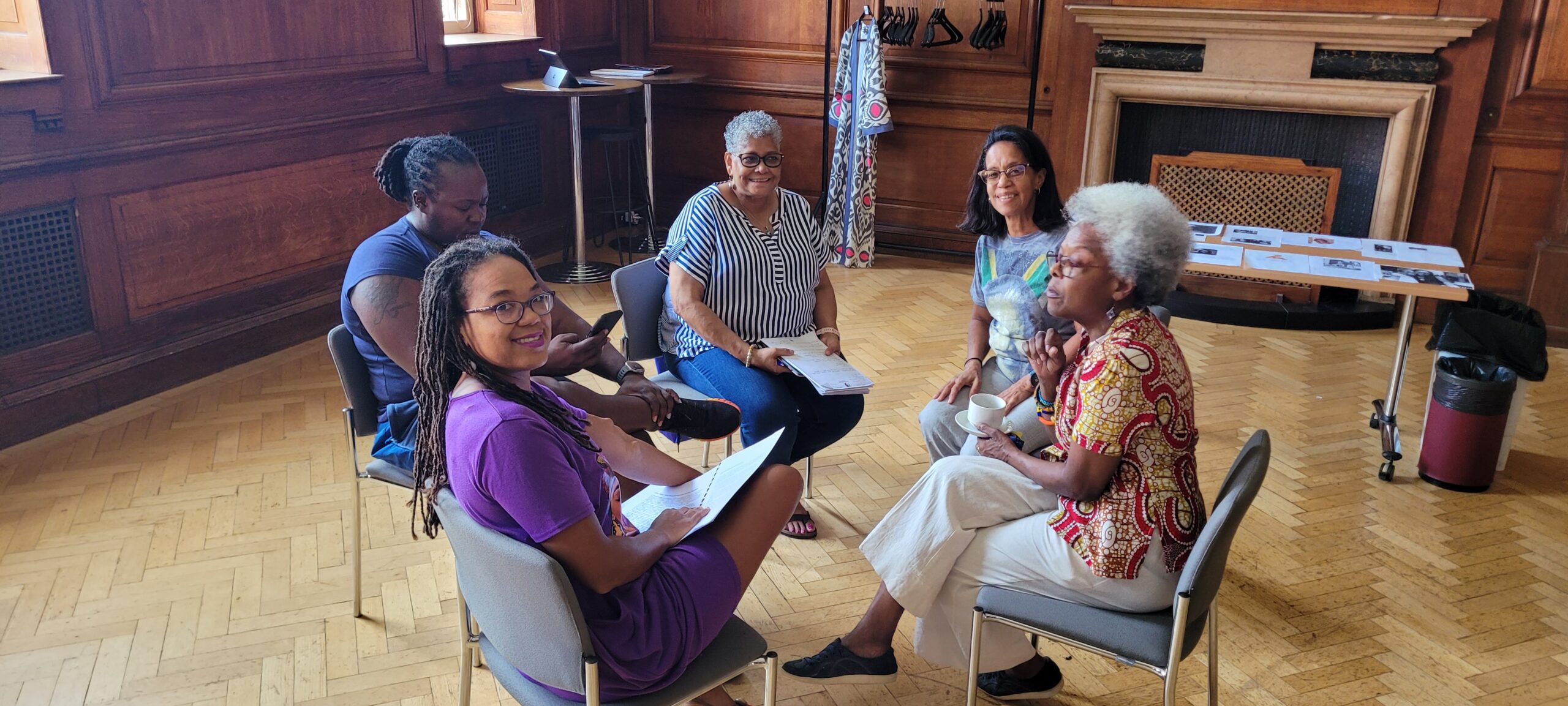 group of five women sitting in a circle posing for photo